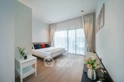 Spacious modern bedroom with elegant decor and large window view.