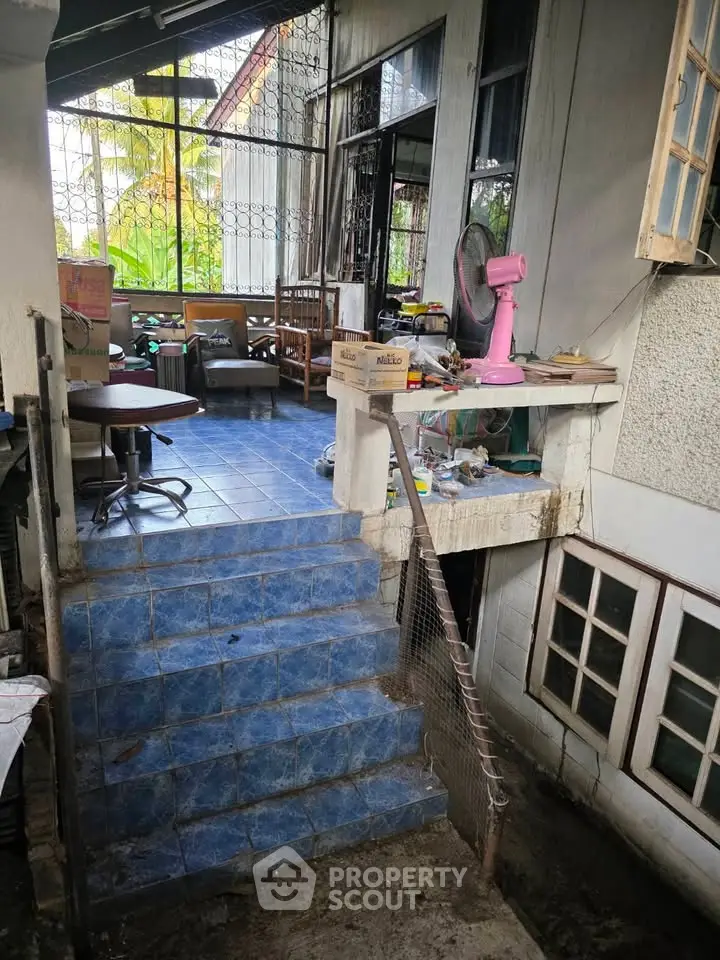 Charming rustic home with blue-tiled steps leading to a cozy outdoor seating area, perfect for relaxation.