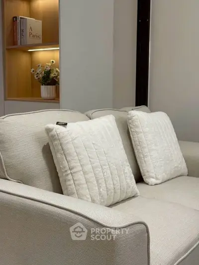 Elegant living room with cozy beige sofa and decorative pillows, perfect for relaxation.