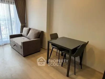 Modern living room with cozy sofa and dining table, featuring floor-to-ceiling windows for natural light.