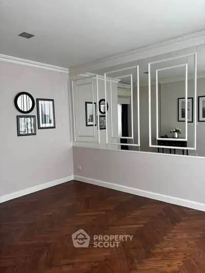 Elegant room with mirrored wall and wooden flooring, perfect for modern living.