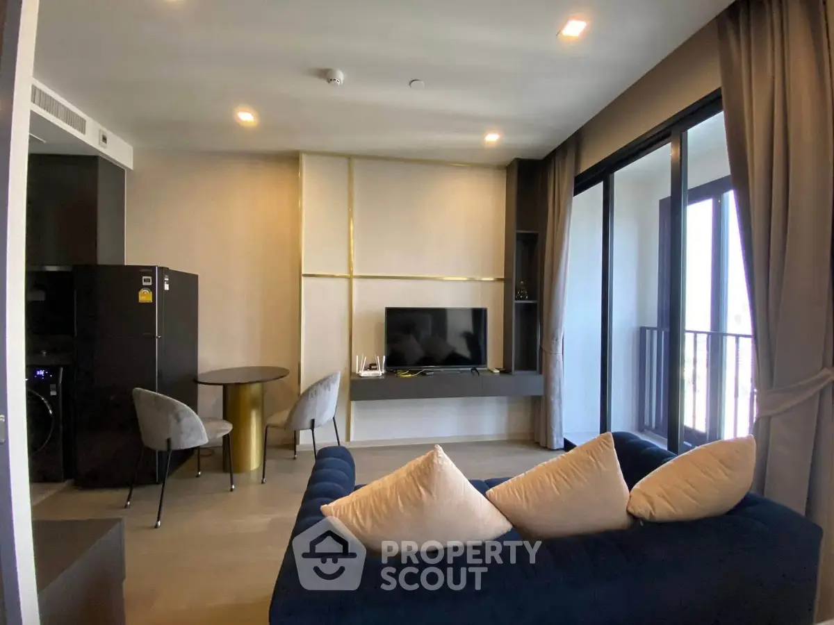 Modern living room with stylish decor and balcony view in a contemporary apartment.