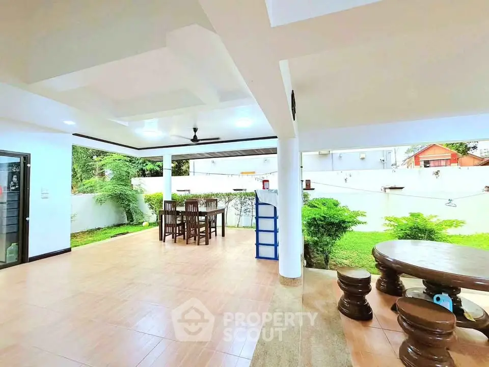 Spacious outdoor patio with elegant seating and lush garden view, perfect for entertaining and relaxation.