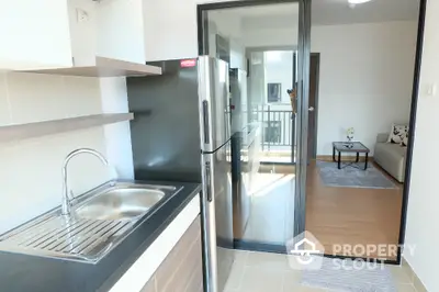 Modern kitchen with sleek design and open layout leading to cozy living room