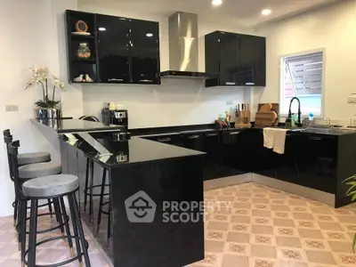 Modern kitchen with sleek black cabinets and breakfast bar seating