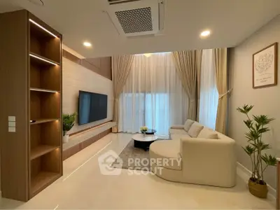 Luxurious modern living room with elegant decor and large windows.