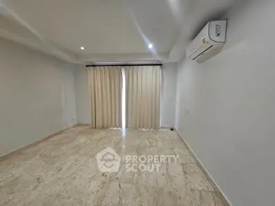 Spacious empty room with marble flooring and air conditioning, ideal for customization.