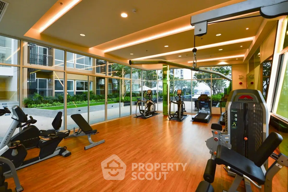 Modern gym with state-of-the-art equipment and large windows overlooking a garden.
