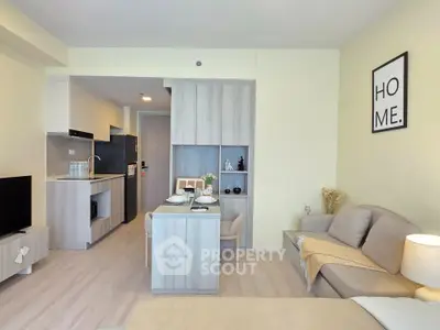 Modern open-plan living room with cozy seating and stylish kitchen area in a contemporary apartment.