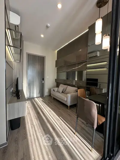 Modern living room with sleek design and stylish furniture, featuring a cozy sofa and elegant lighting.