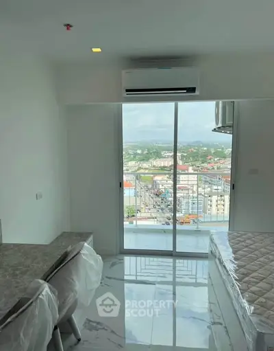 Modern bedroom with city view and balcony access, featuring sleek marble flooring and air conditioning.