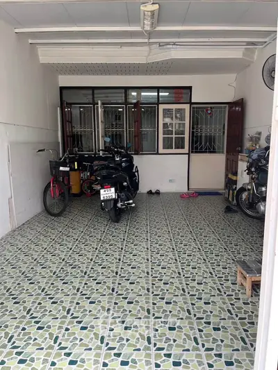 Spacious garage with tiled floor and ample space for vehicles and storage.