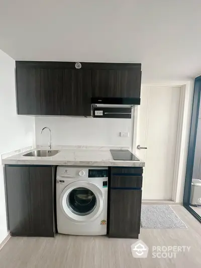 Modern compact kitchen with washing machine and sleek cabinetry