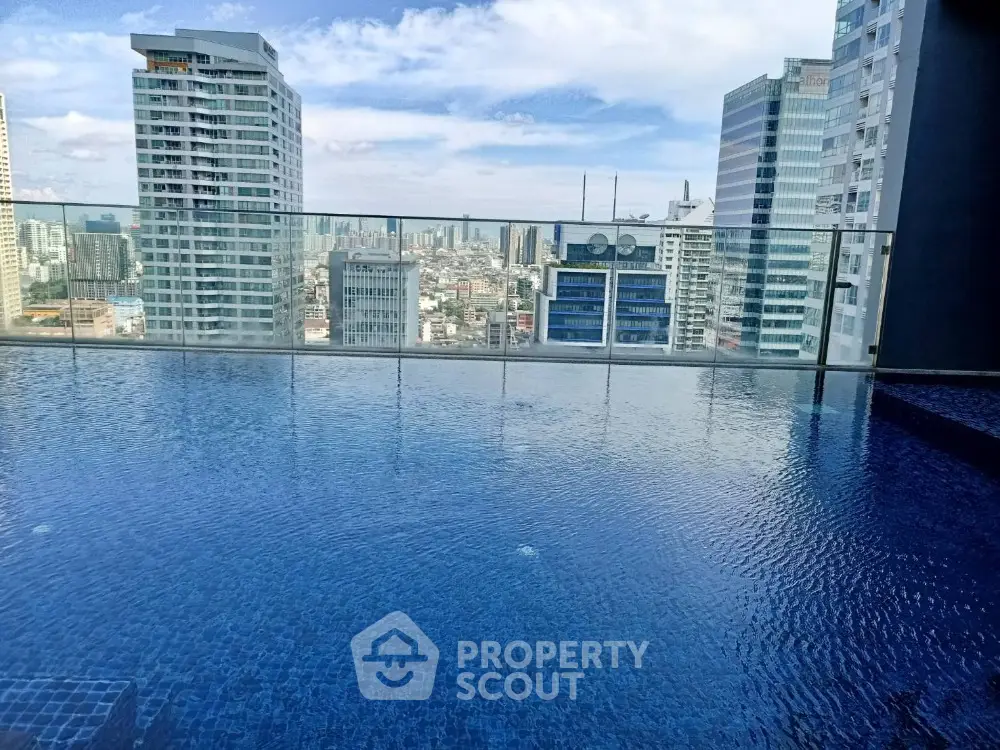 Stunning rooftop pool with panoramic city skyline views in modern high-rise building.