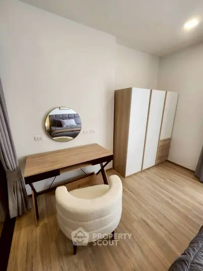 Modern bedroom with stylish wooden furniture and cozy chair, featuring a sleek wardrobe and elegant mirror.