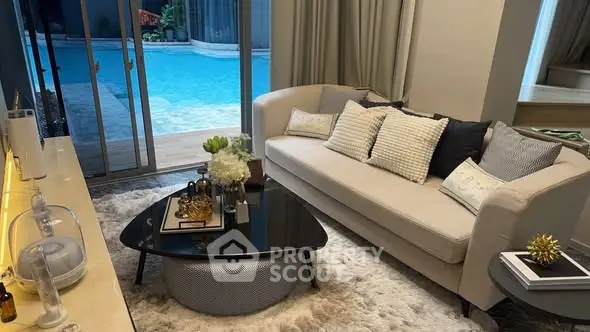 Luxurious living room with pool view, elegant decor, and plush furnishings for ultimate comfort and style.