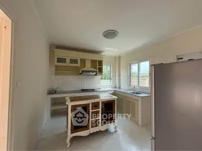 Charming kitchen with vintage island and modern appliances in a bright, airy space.