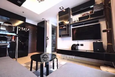 Modern living room with sleek black furniture and wall-mounted TV in stylish apartment.