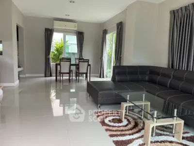 Spacious modern living room with sleek furniture and dining area, perfect for family gatherings.