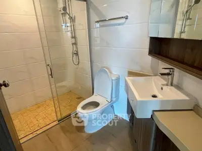 Modern bathroom with glass shower and sleek fixtures in a contemporary apartment.