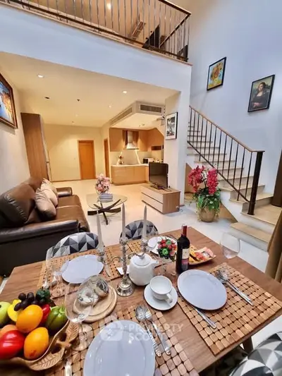 Luxurious open-plan living room with elegant dining setup and modern kitchen in a stylish duplex apartment.