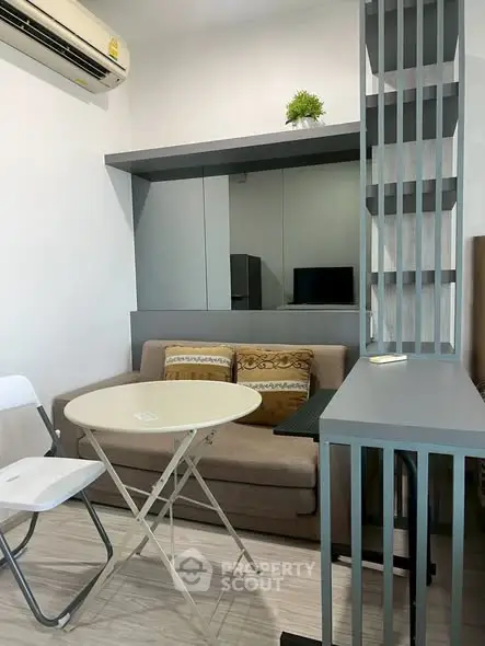 Cozy living room with modern decor and air conditioning, perfect for relaxation.