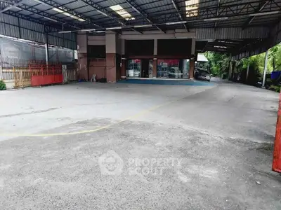 Spacious covered parking area with industrial design and ample space for vehicles.