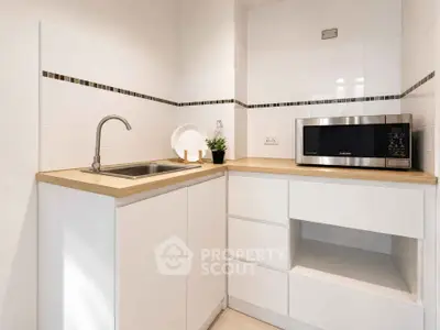 Modern kitchen with sleek white cabinets and built-in microwave