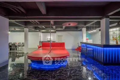 Luxurious modern living room with unique red seating and stylish bar area, perfect for entertaining.
