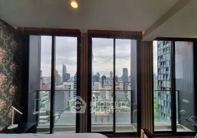 Luxurious bedroom with stunning city view through floor-to-ceiling windows in modern high-rise apartment.