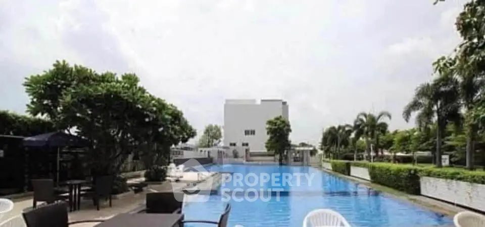 Luxurious outdoor pool area with lush greenery and modern seating, perfect for relaxation and leisure.