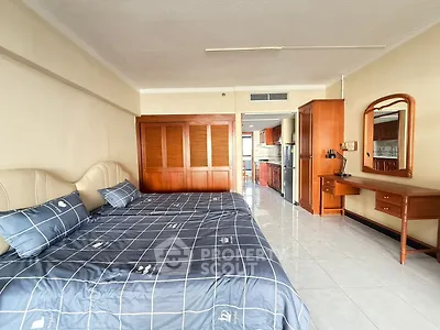 Spacious bedroom with elegant wooden furniture and modern kitchen view