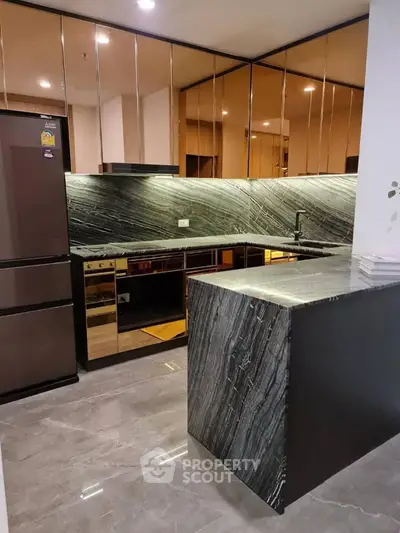 Luxurious modern kitchen with sleek black marble countertops and high-end appliances.