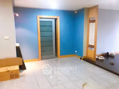 Spacious modern living room with blue accent wall and sleek door design