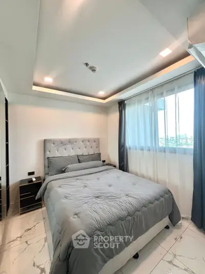 Modern bedroom with stylish decor and large windows offering natural light