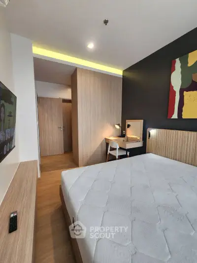 Modern bedroom with stylish decor and natural wood accents, featuring a comfortable bed and workspace.