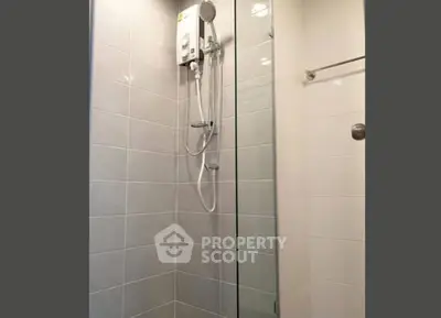 Modern bathroom with glass shower enclosure and sleek tile design.