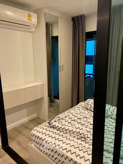 Cozy bedroom with modern decor and mirrored wardrobe in a stylish apartment.