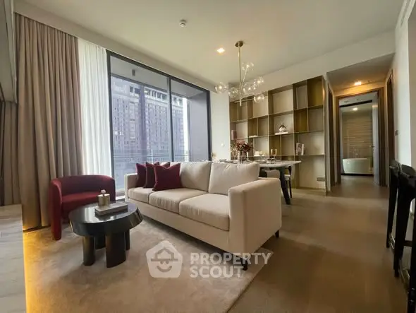 Luxurious modern living room with elegant decor and city view, featuring a chic chandelier and cozy seating area.