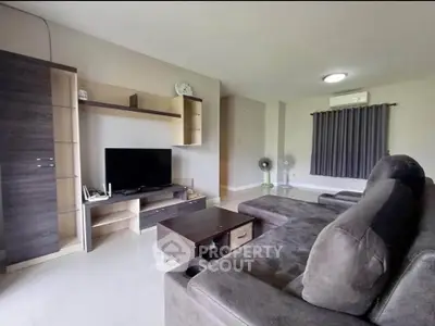 Spacious living room with modern furniture and entertainment center.