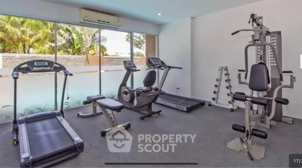 Modern gym with state-of-the-art equipment and large windows offering natural light.