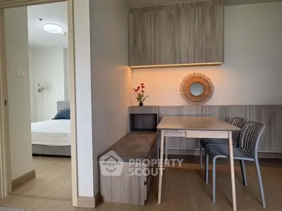 Modern apartment interior with stylish dining area and glimpse of cozy bedroom