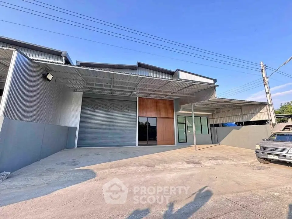 Spacious industrial warehouse with modern exterior and ample parking space.