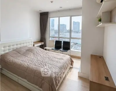 Modern bedroom with city view, featuring sleek furniture and ample natural light.
