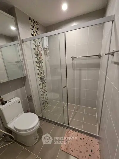 Modern bathroom with glass shower enclosure and stylish tile accents