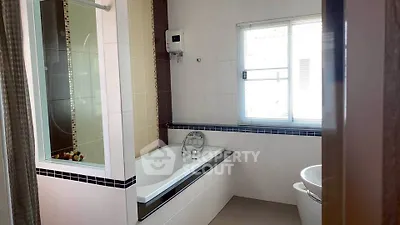 Modern bathroom with bathtub and natural light from window