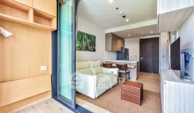 Modern open-plan living room with cozy seating and sleek kitchen in a stylish apartment.