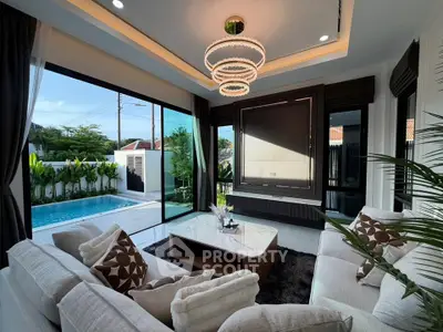 Luxurious living room with pool view, modern decor, and elegant lighting in a stylish home.