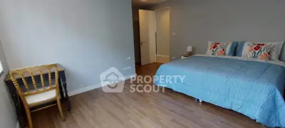 Spacious bedroom with wooden flooring and stylish decor