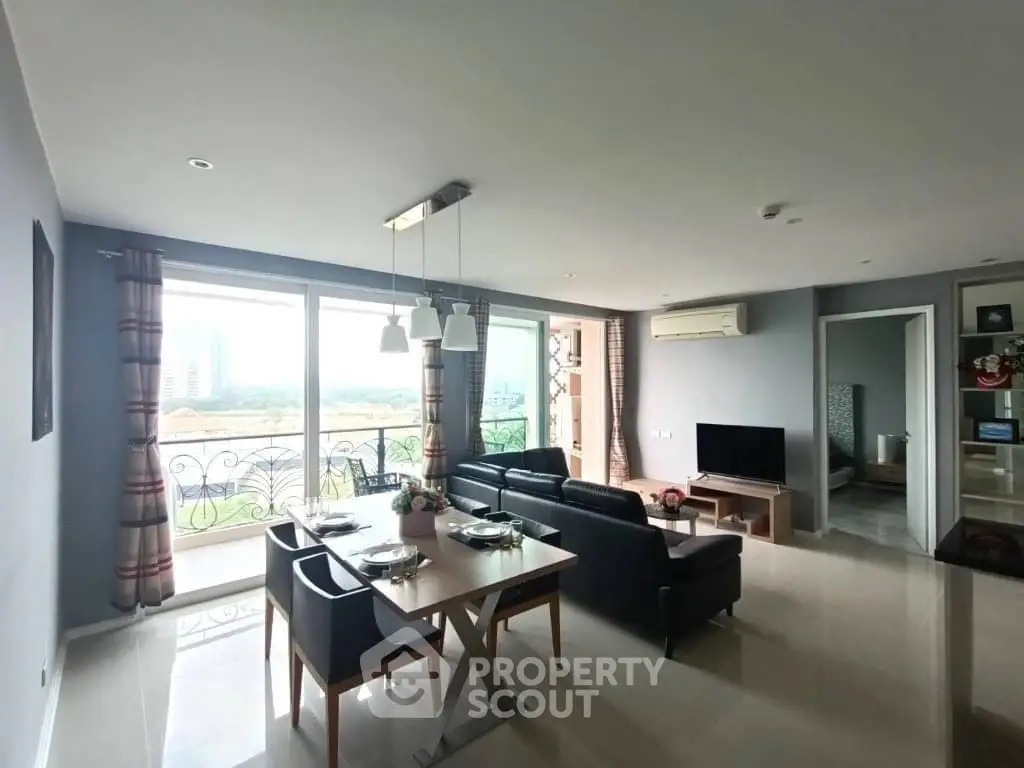Spacious modern living room with large windows and elegant dining area